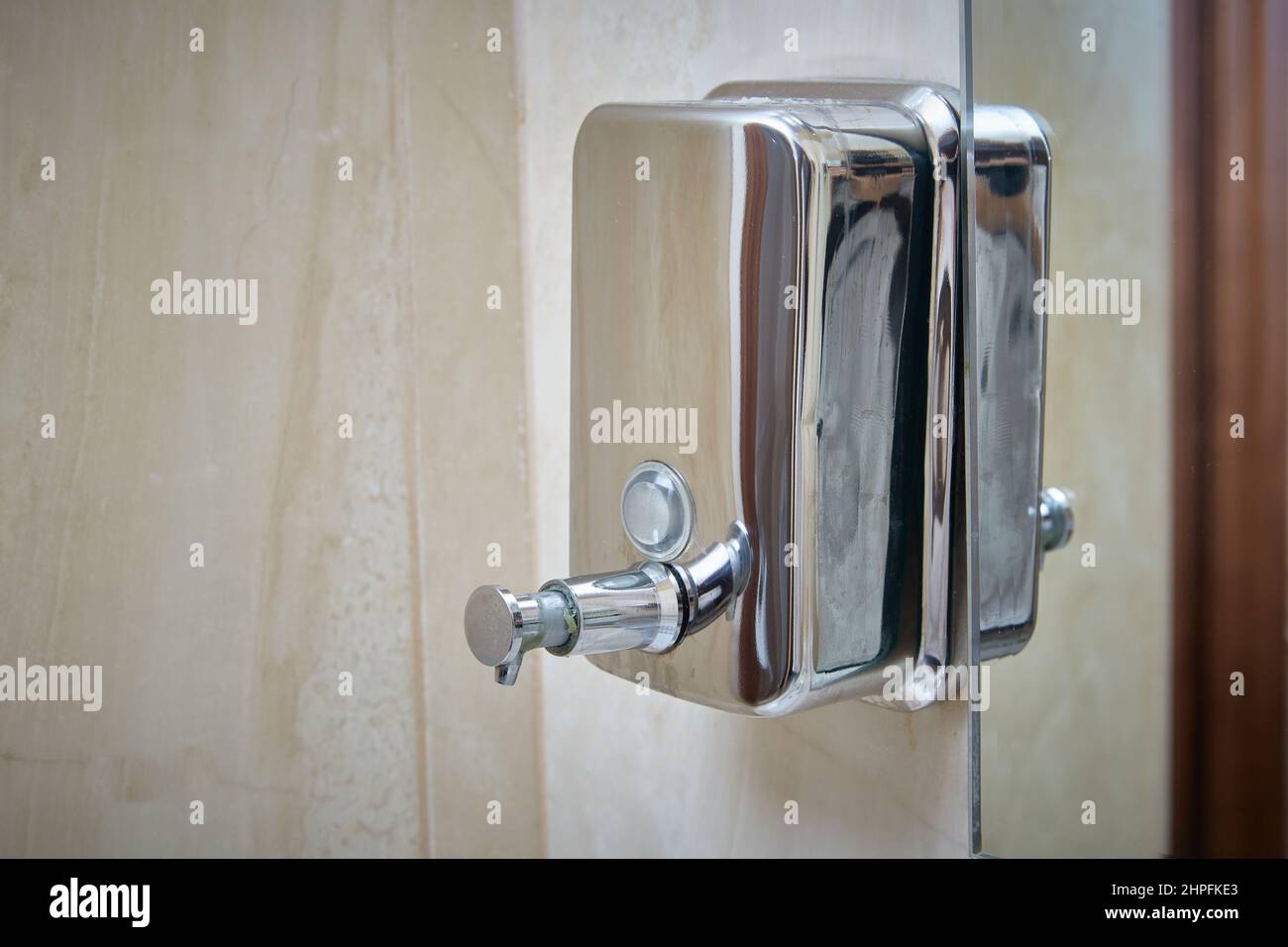towel Metal dispenser for soap or disinfectant. Stock Photo