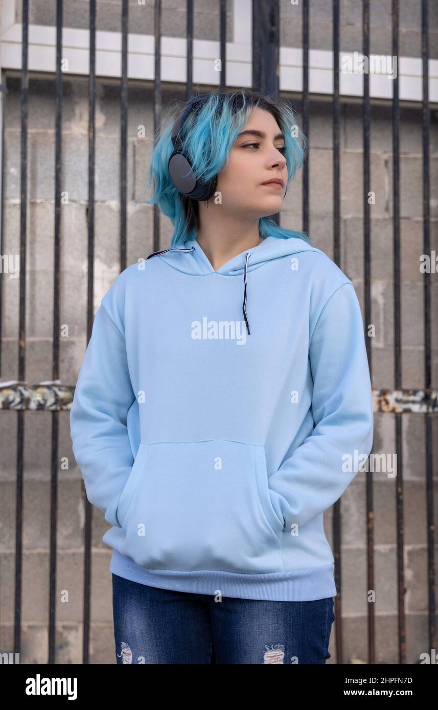 Teenager wearing light blue oversize hoodie looking right. Blue haired ...
