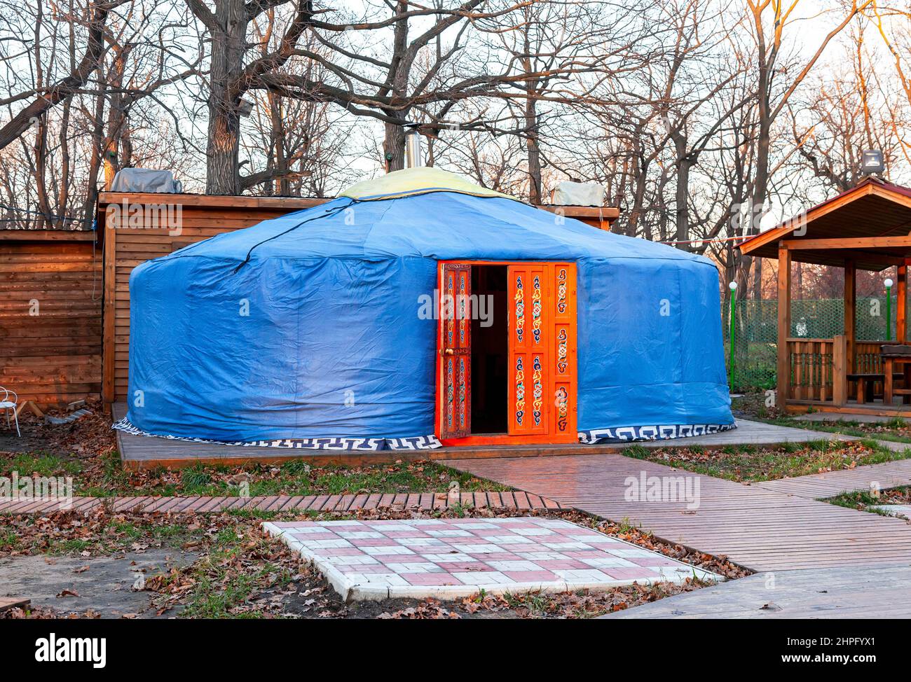 Traditional Kazakh yurt with big decorated orange door outdoors Stock Photo