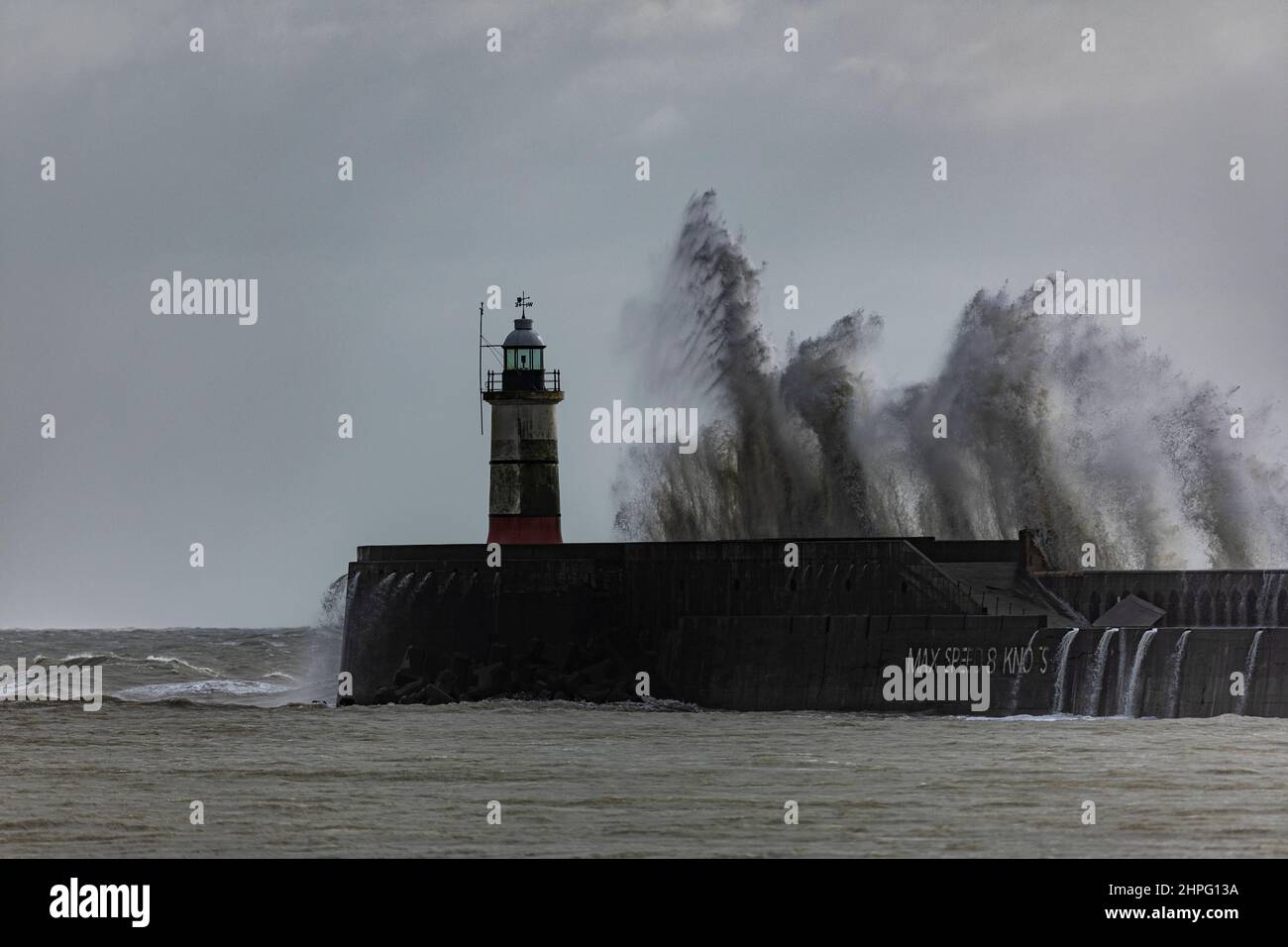 Newhaven Lighthouse, UK, 21st February 2022. Newhaven Lighthouse sea wall hit by strong waves as Storm Franklin sweeps thought parts of the south coast of England. Credit: Steven Paston/Alamy Live News Stock Photo