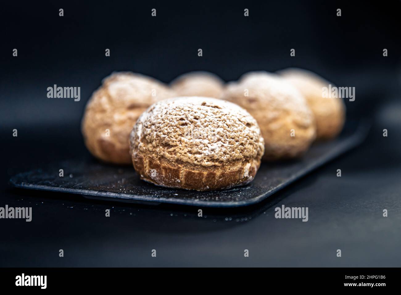 Appetizing Shu cakes on a black background. Stock Photo