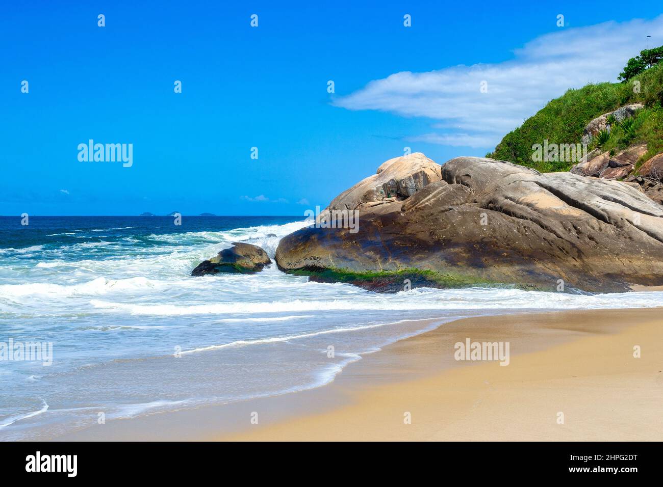 Sea waves crashing in sand and rocks. Camboinhas beach if a famous place and a travel destination in the State of Rio de Janeiro. Stock Photo
