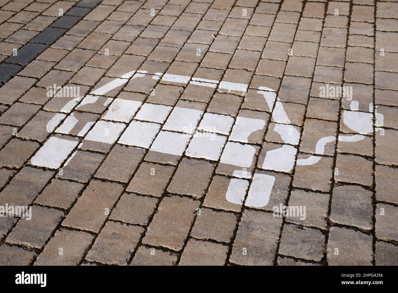 Sign for a parking space for electric vehicles with charging station painted on the cobblestones. Seen in Germany in Haimendorf on a sunny February da Stock Photo