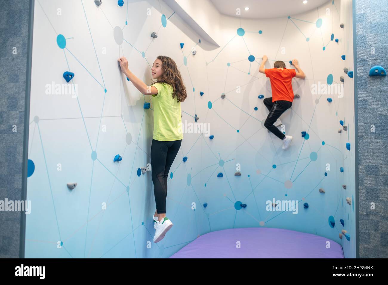 Children rock climbing on training wall Stock Photo Alamy