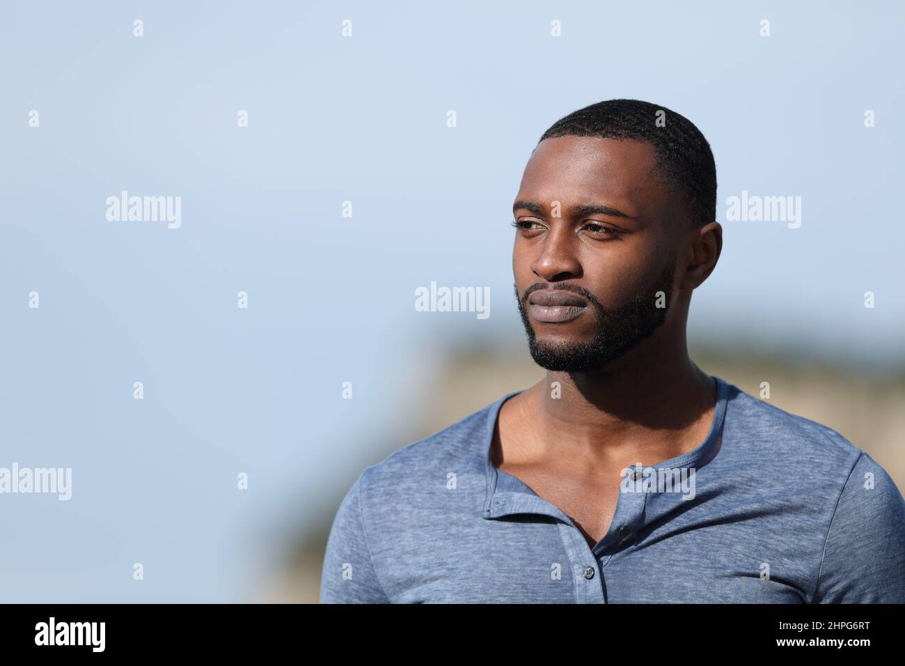 Serious man with black skin contemplating views outdoors Stock Photo