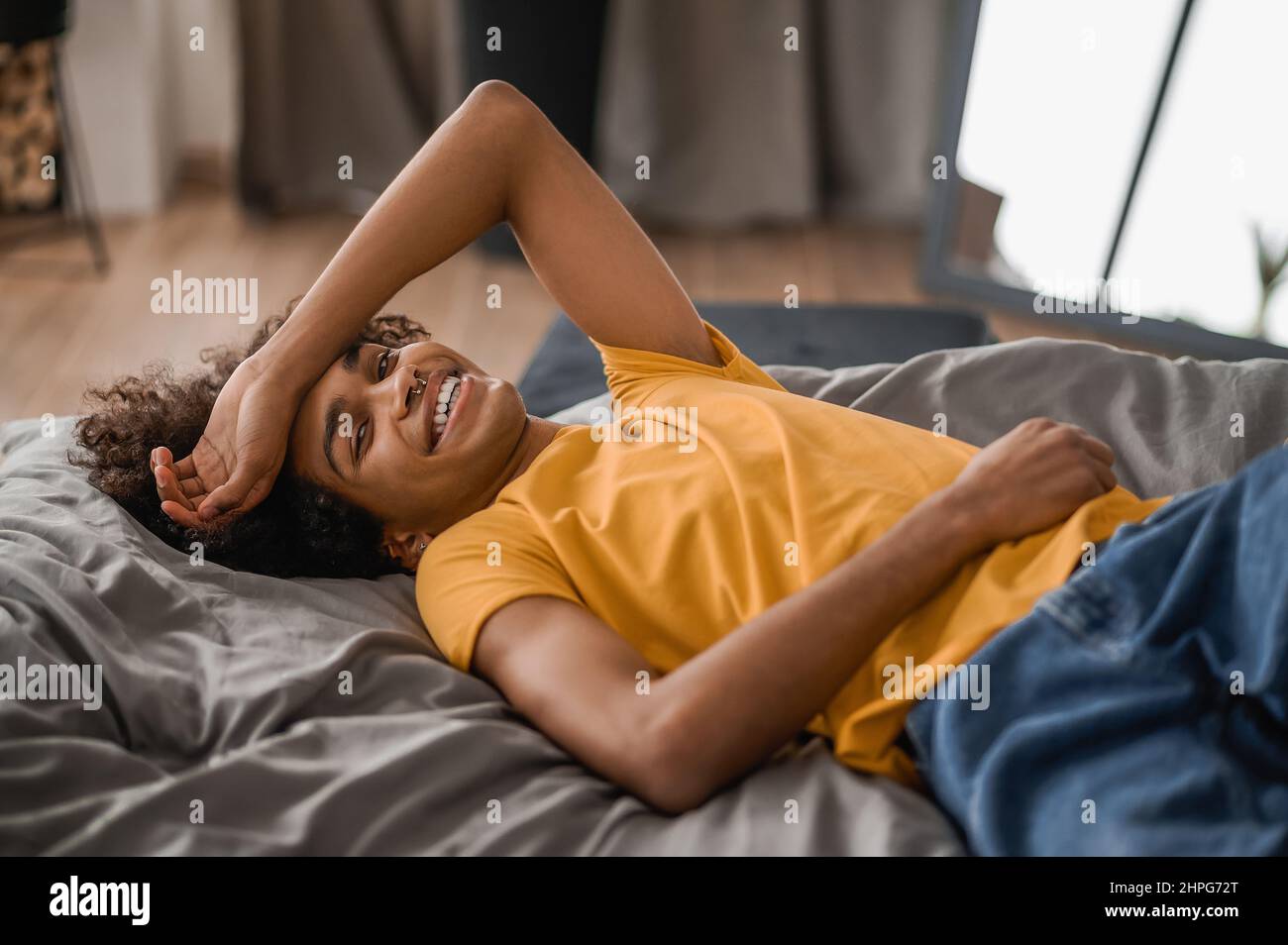 Curly-haired young mulatto resting at home Stock Photo
