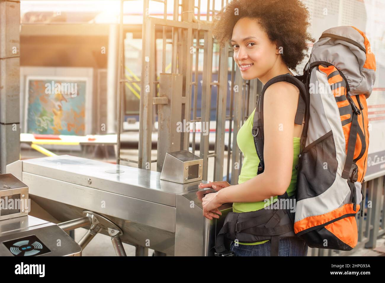 Cheerful female tourist going through slot for tickets and travel cards Stock Photo