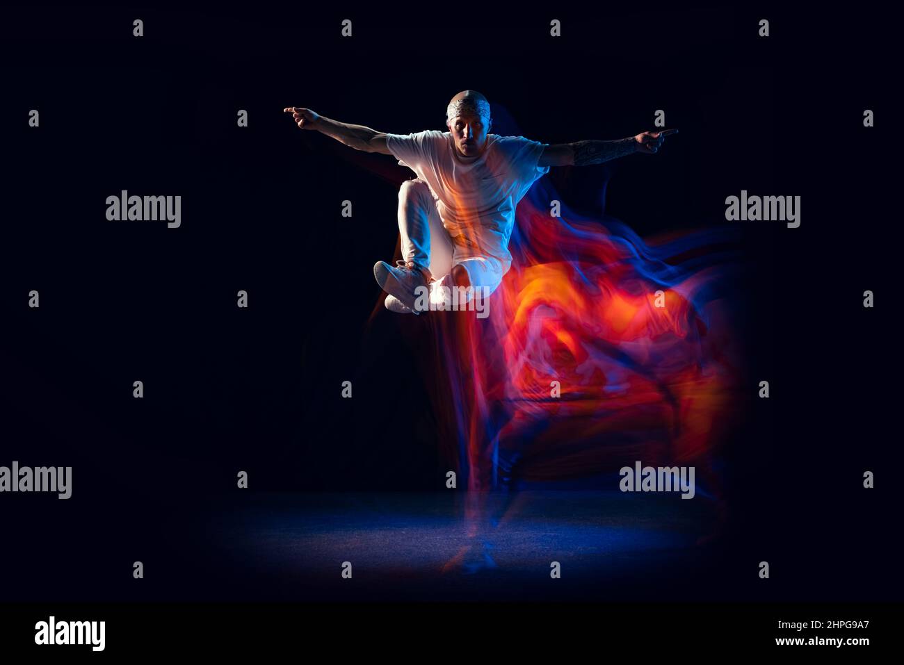 Jumping. Stylish man in sports white outfit dancing hip-hop, breakdance ...