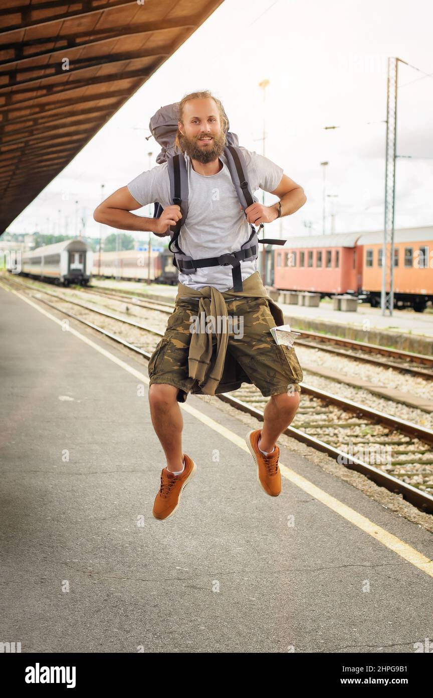 Happy male tourist jumping at the railway station Stock Photo Alamy