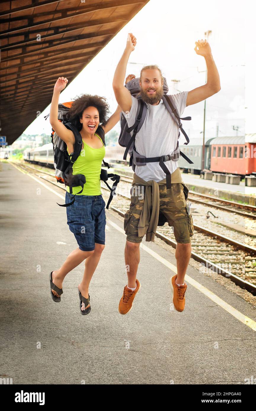 Two happy tourists jumping at the railway station Stock Photo Alamy