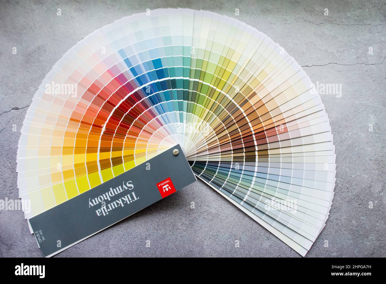 Moscow, Russia, June 2021: Paper Palette Fan Tikkurila paint samples - interior design wall painting. Gray concrete background. Stock Photo