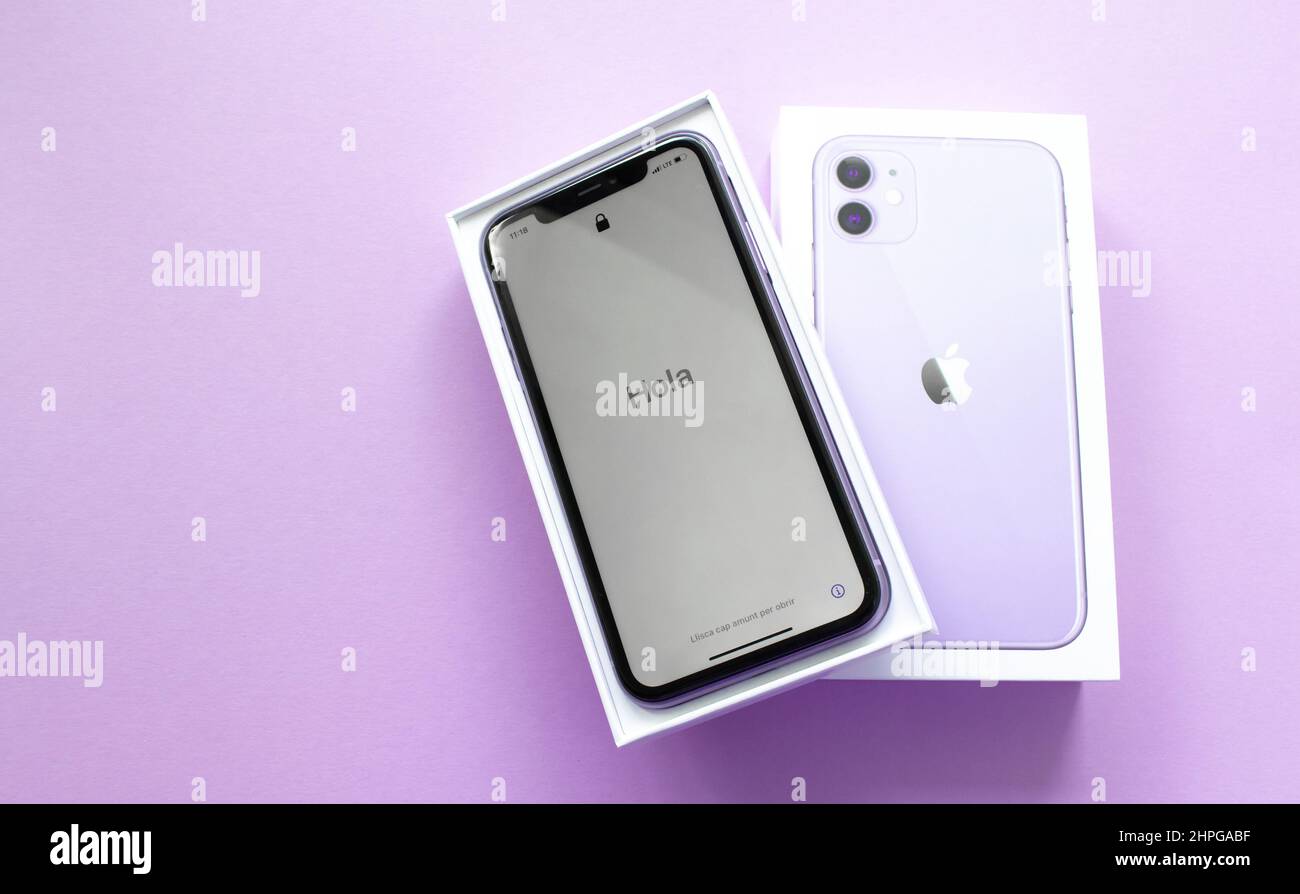 Moscow, Russia, May 2021: A new iPhone 12 model of violet color in an open branded box on a lilac background. On the iPhone screen, a welcome in Spani Stock Photo