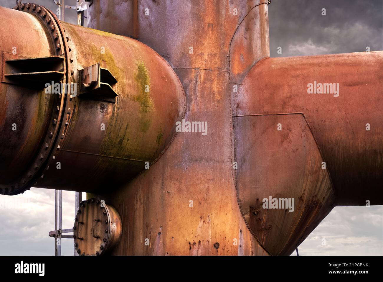 Abstract looking confluence of large iron pipes completely covered with rust Stock Photo