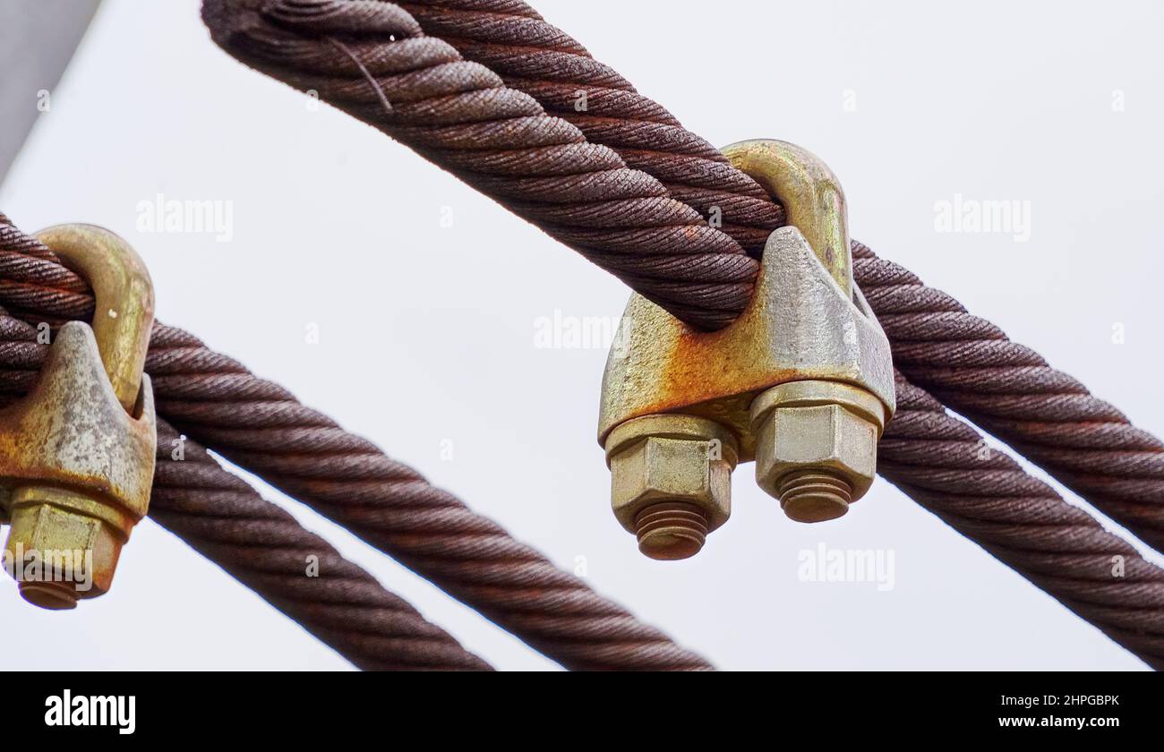 Clamp connection with bolts on thick steel cables from steel threads Stock Photo