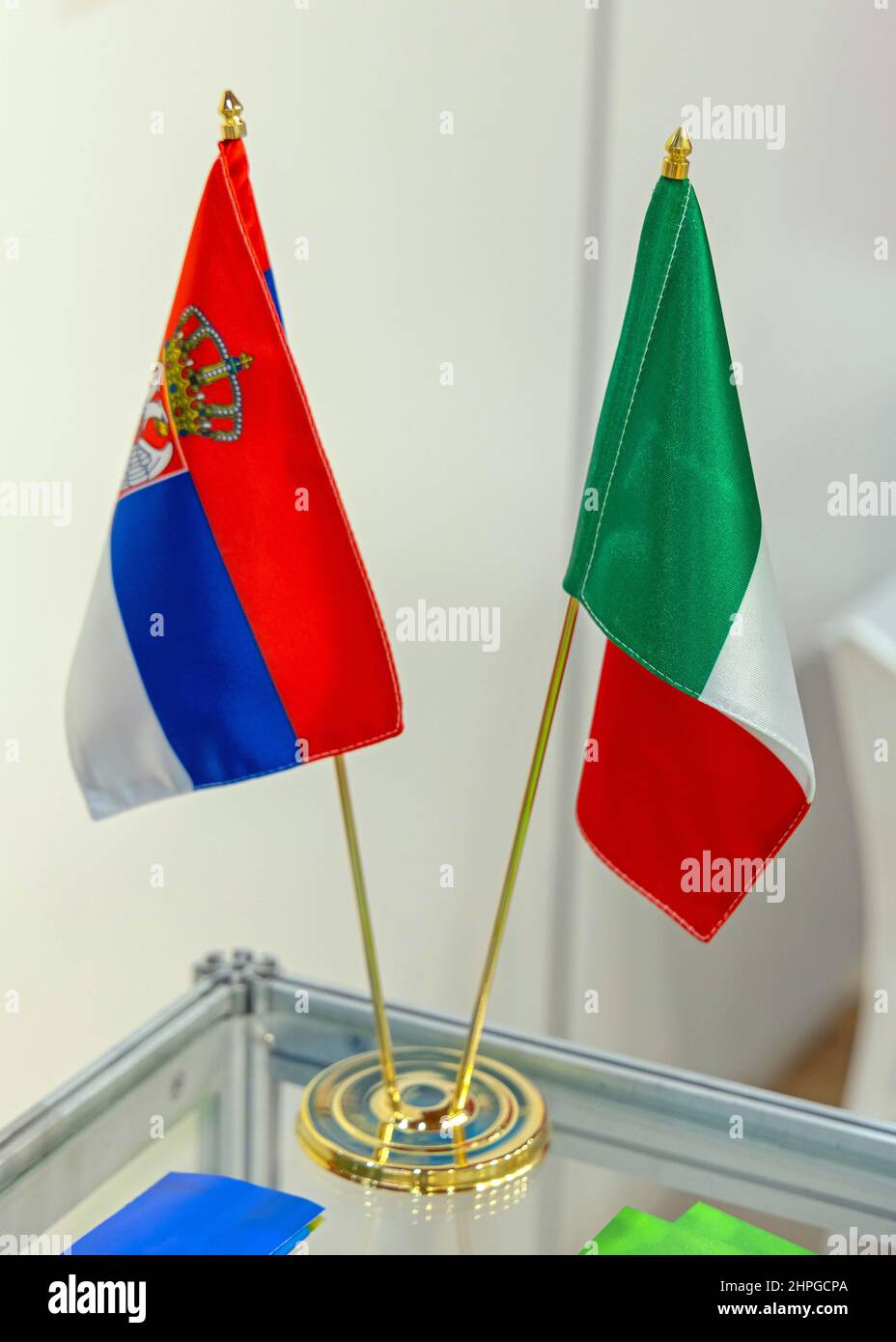 Small Serbian and Italian Flags Together in Holder at Table Top Stock Photo