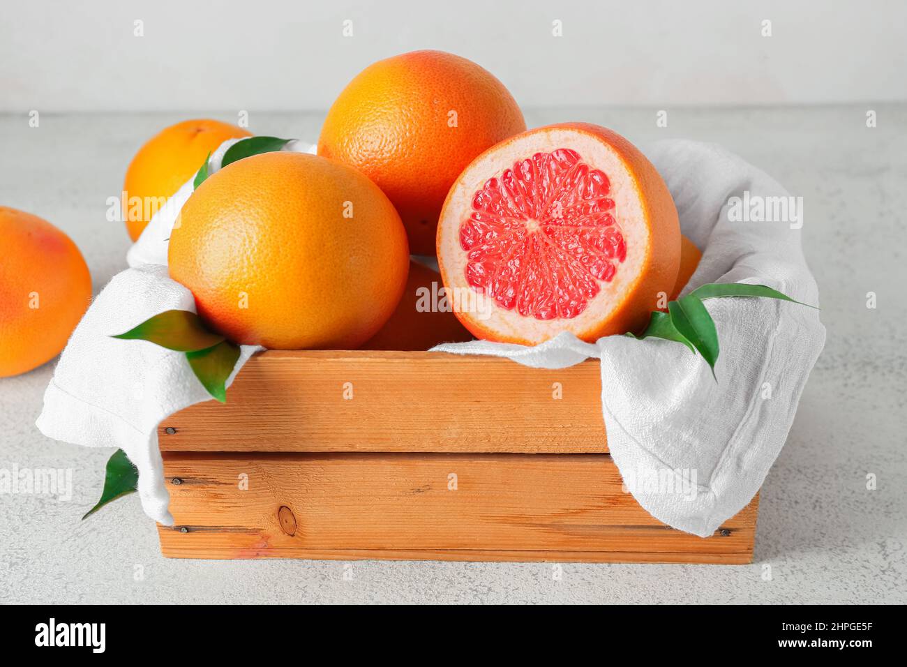 Box with delicious grapefruits on light background Stock Photo