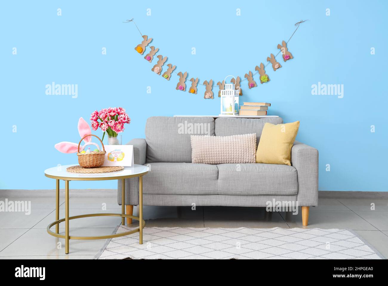 Interior of stylish living room with tulips in vase and Easter decor Stock Photo