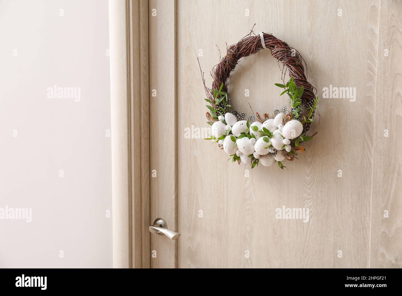 Beautiful Easter wreath hanging on door Stock Photo