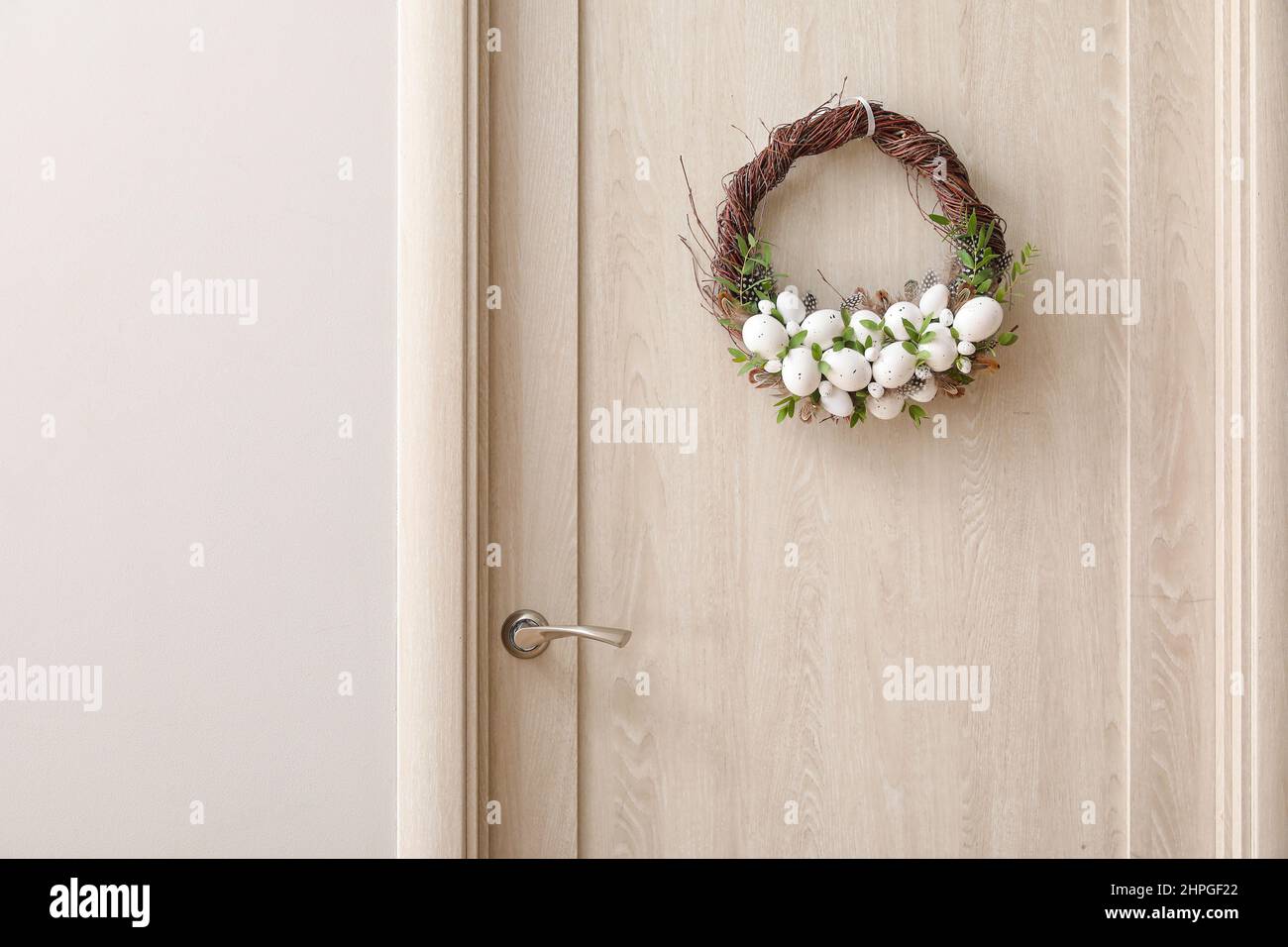 Beautiful Easter wreath hanging on door Stock Photo