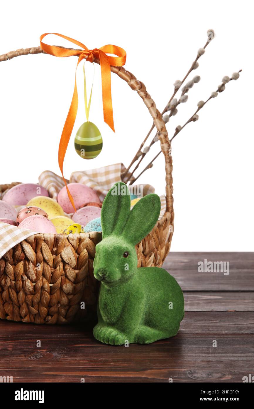 Basket with painted Easter eggs, willow branches and bunny on wooden ...