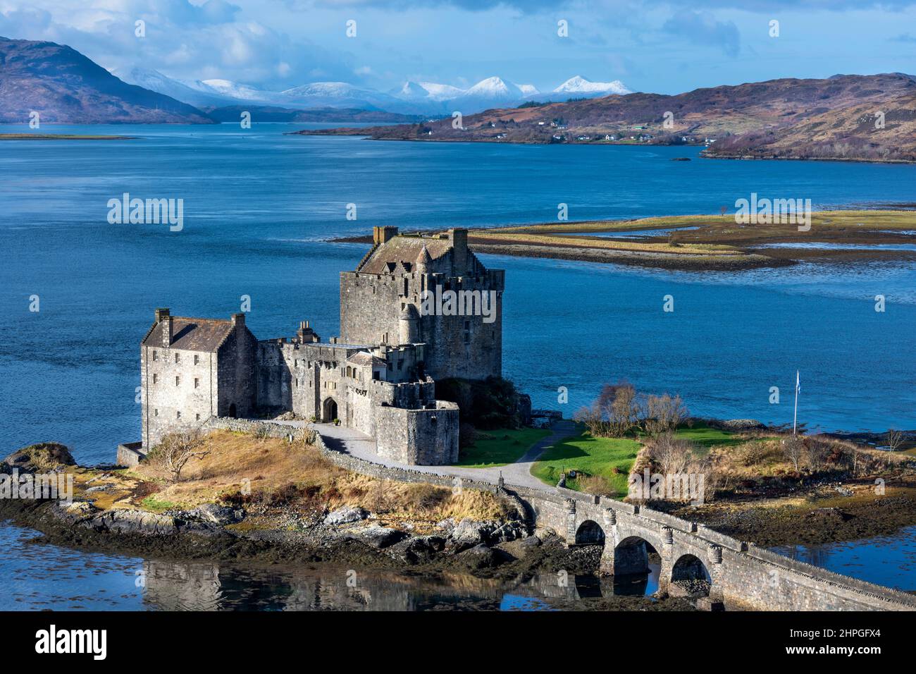 EILEAN DONAN CASTLE LOCH DUICH SCOTLAND BLUE SEA AND A RECENT FALL OF SNOW ON THE HILLS Stock Photo