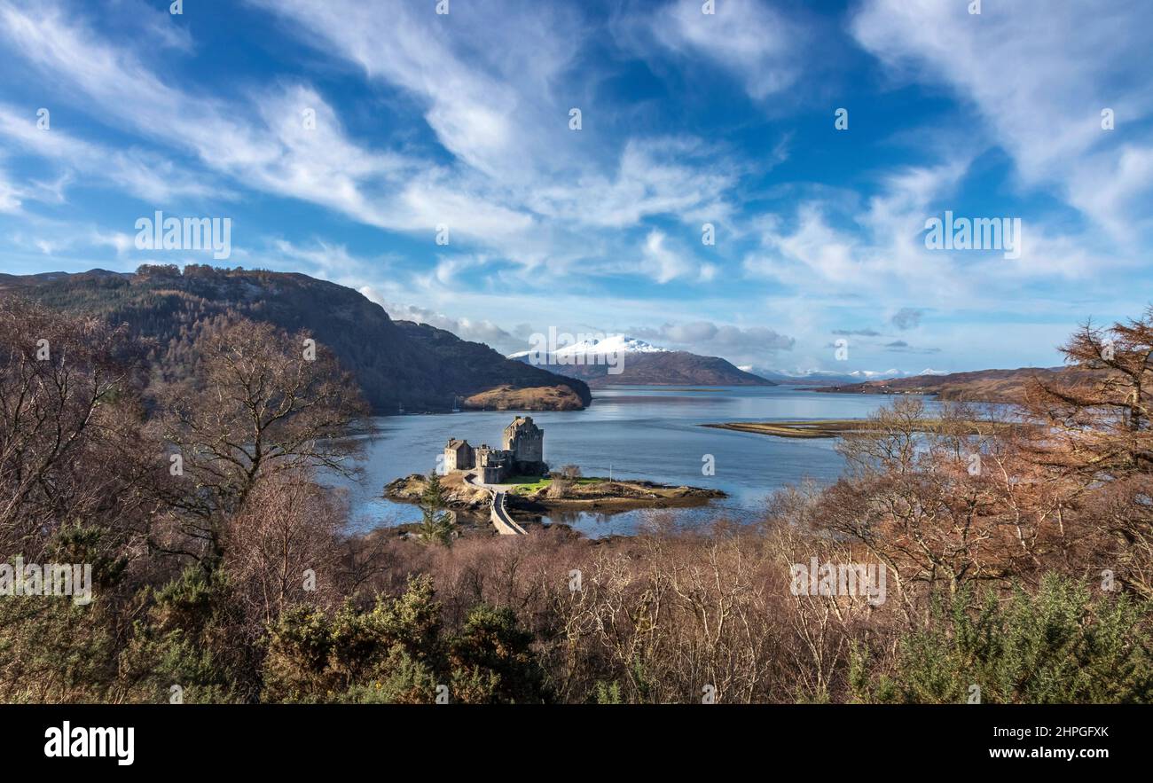 EILEAN DONAN CASTLE LOCH DUICH SCOTLAND BLUE SEA TREES IN WINTER AND A RECENT FALL OF SNOW ON THE HILLS Stock Photo