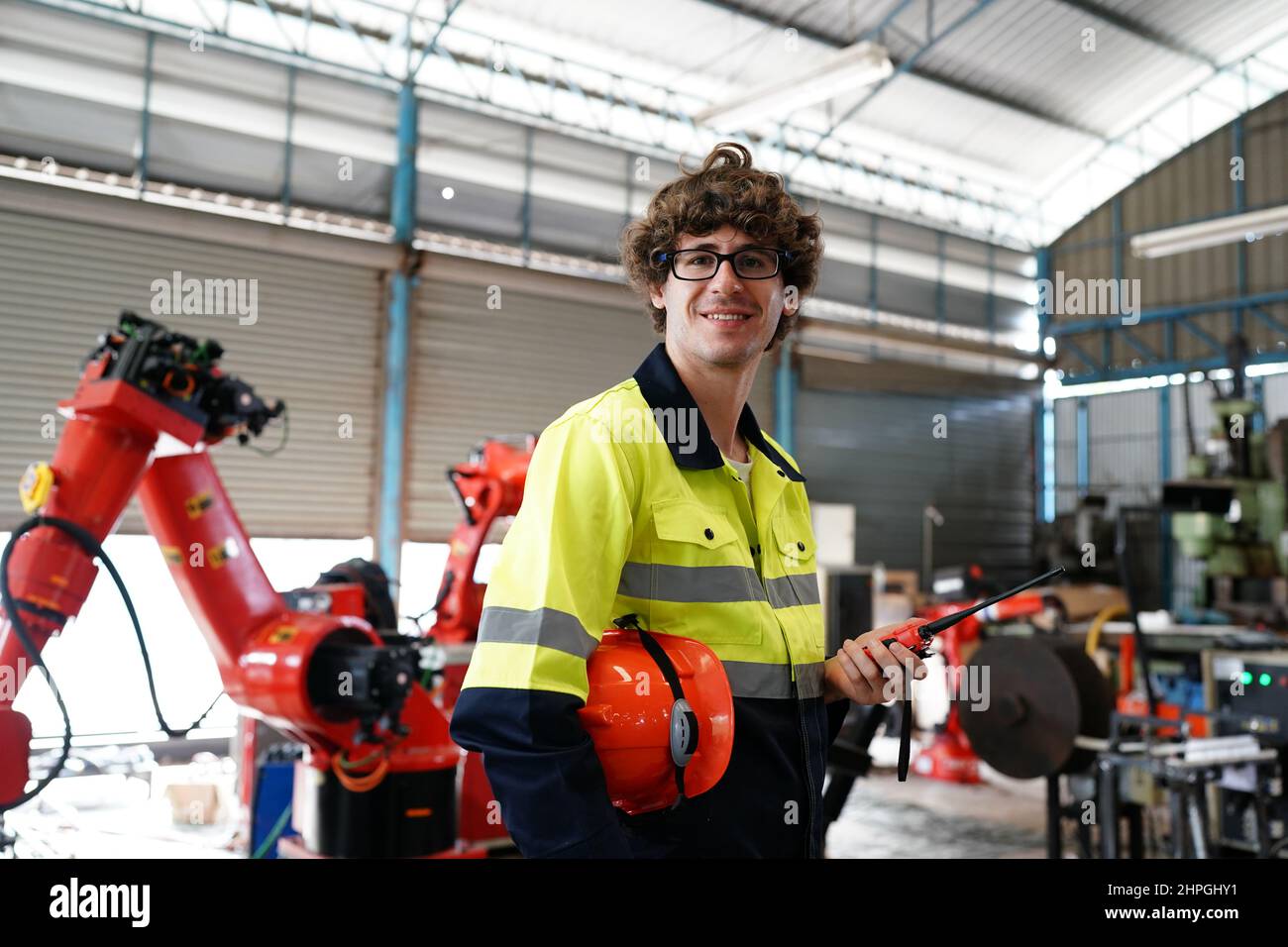 engineer checking control panel and teaching new Automatics robot arm and operating control machine in factory. Stock Photo