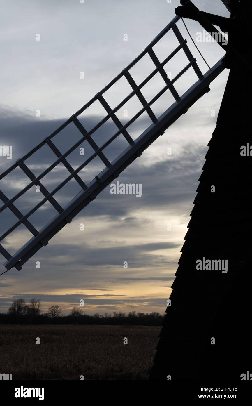 Silhouetted windmill sail at sunset, Wicken Fen National Nature Reserve, Cambridgeshire, England. Stock Photo