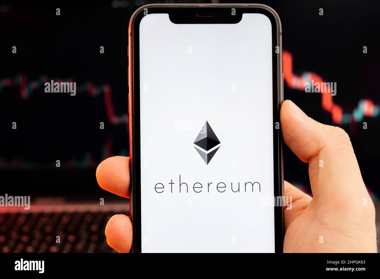 Ethereum ETH app of cryptocurrency stock market analysis on the screen of  mobile phone in man hands and downtrend charts trading data on the  background, February 2022, San Francisco, USA Stock Photo -
