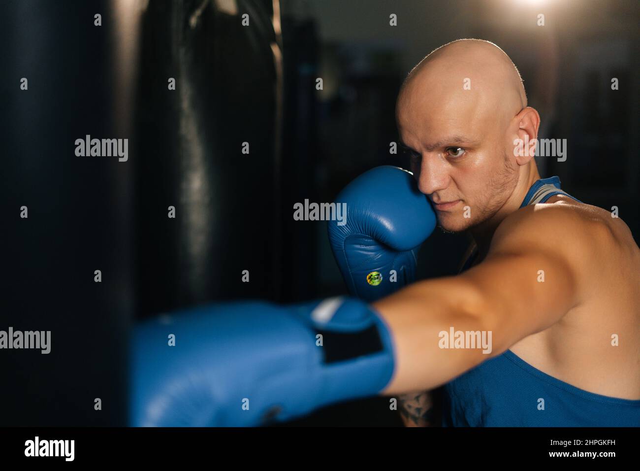 Closeup of anger bald boxer male training punches, beating punching