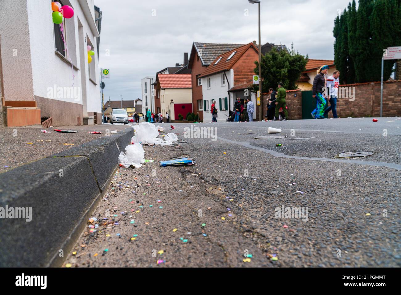 Bornheim, North Rhine-Westphalia, Germany - February 22, 2020: Trash recklessly dumped on the street after a carnival parade. People wearing costumes. Stock Photo