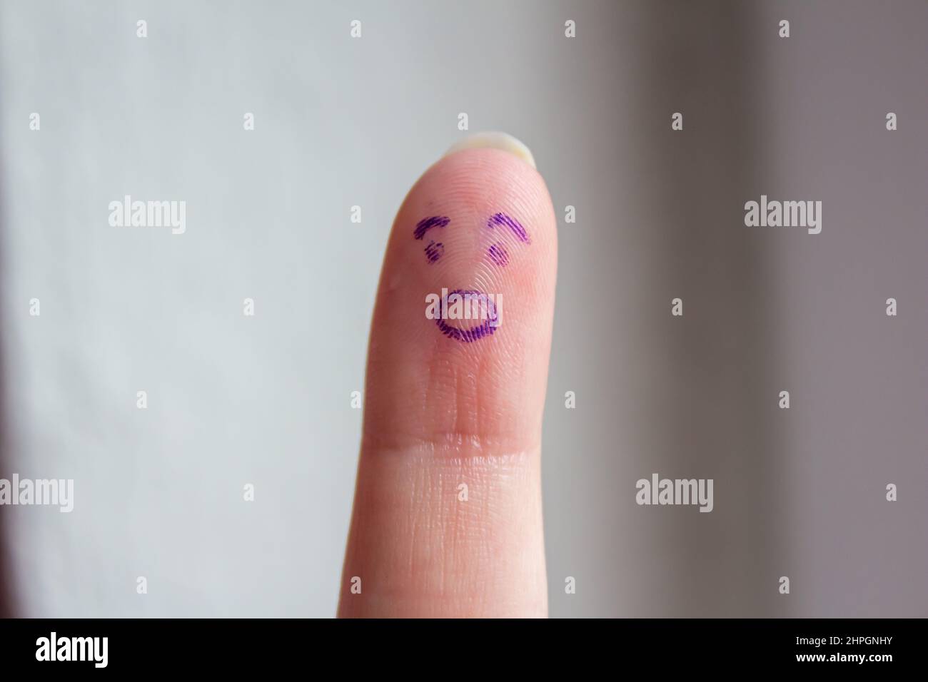 Shocked face drawn on finger, closeup. Funny facial expression on finger. Stock Photo