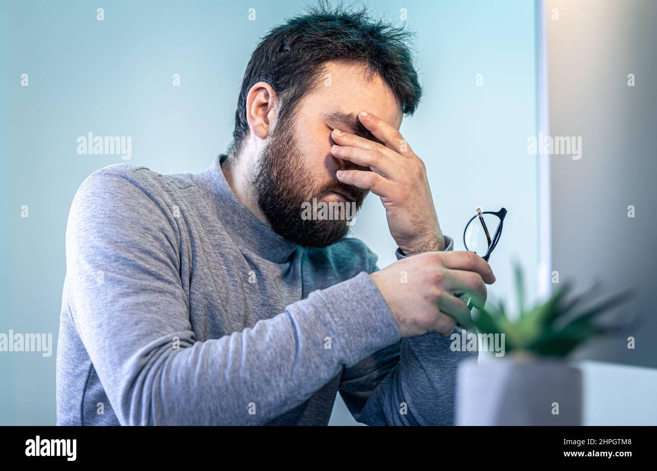 A tired man rubs his eyes in front of a computer screen Stock Photo - Alamy