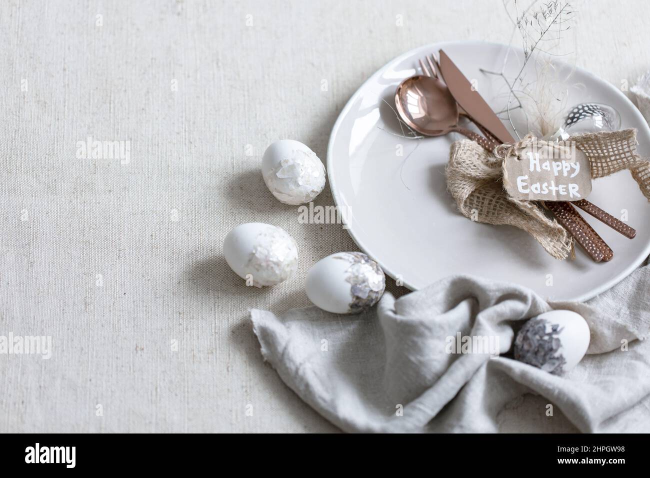 Festive Easter table setting with decor details on white table. Stock Photo