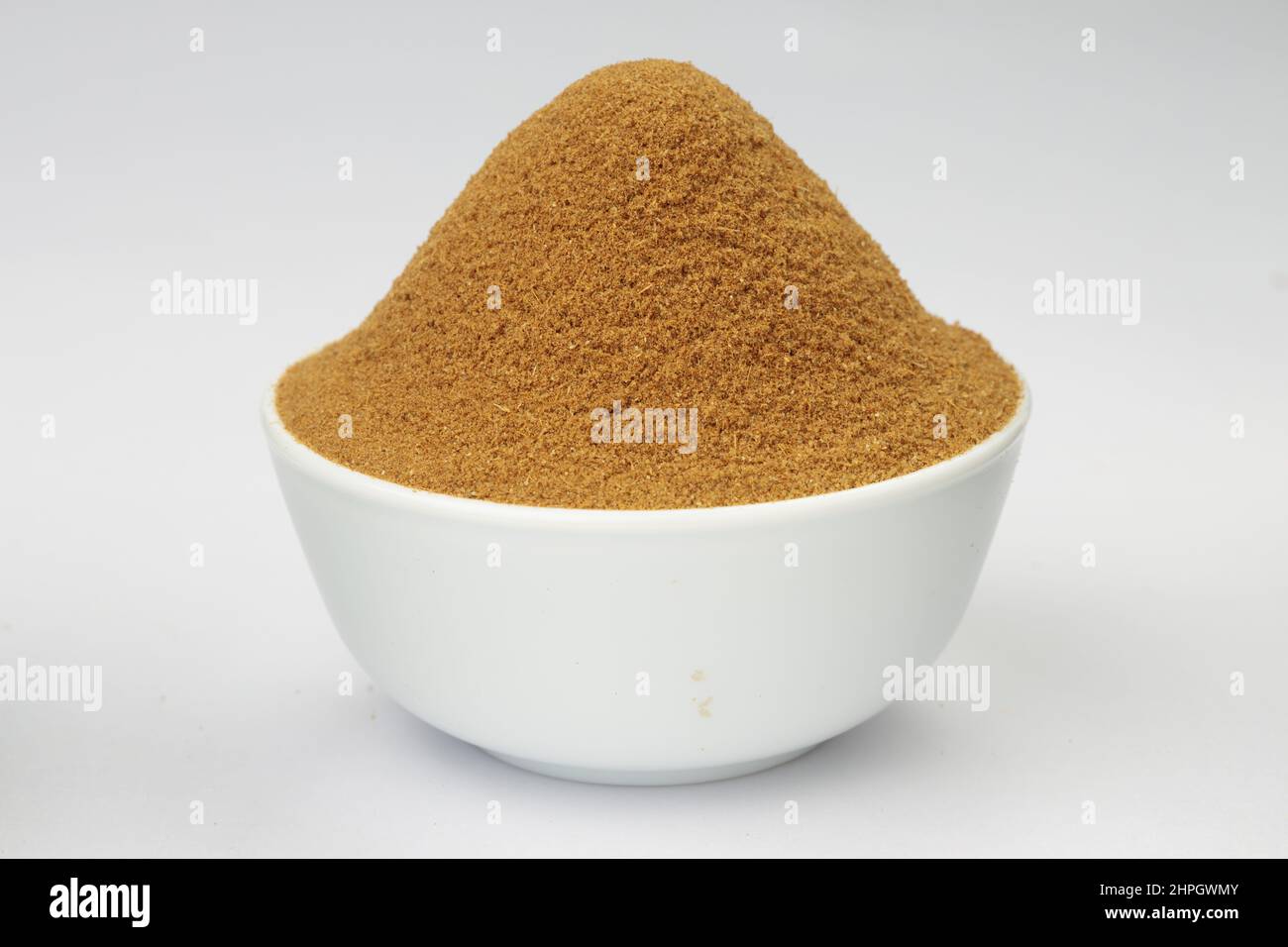 Cumin powder,Indian spices ;arranged on a white textured background