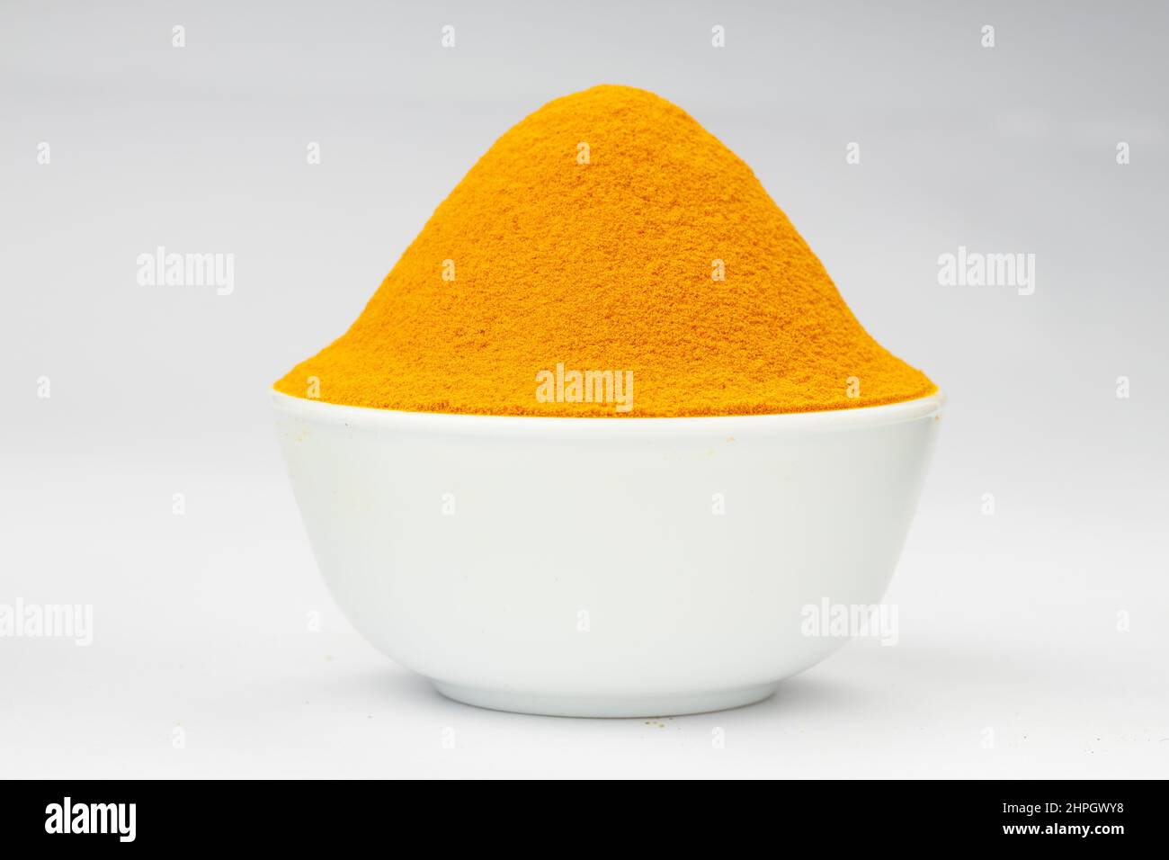 Turmeric powder arranged in a white bowl with white texture or ...