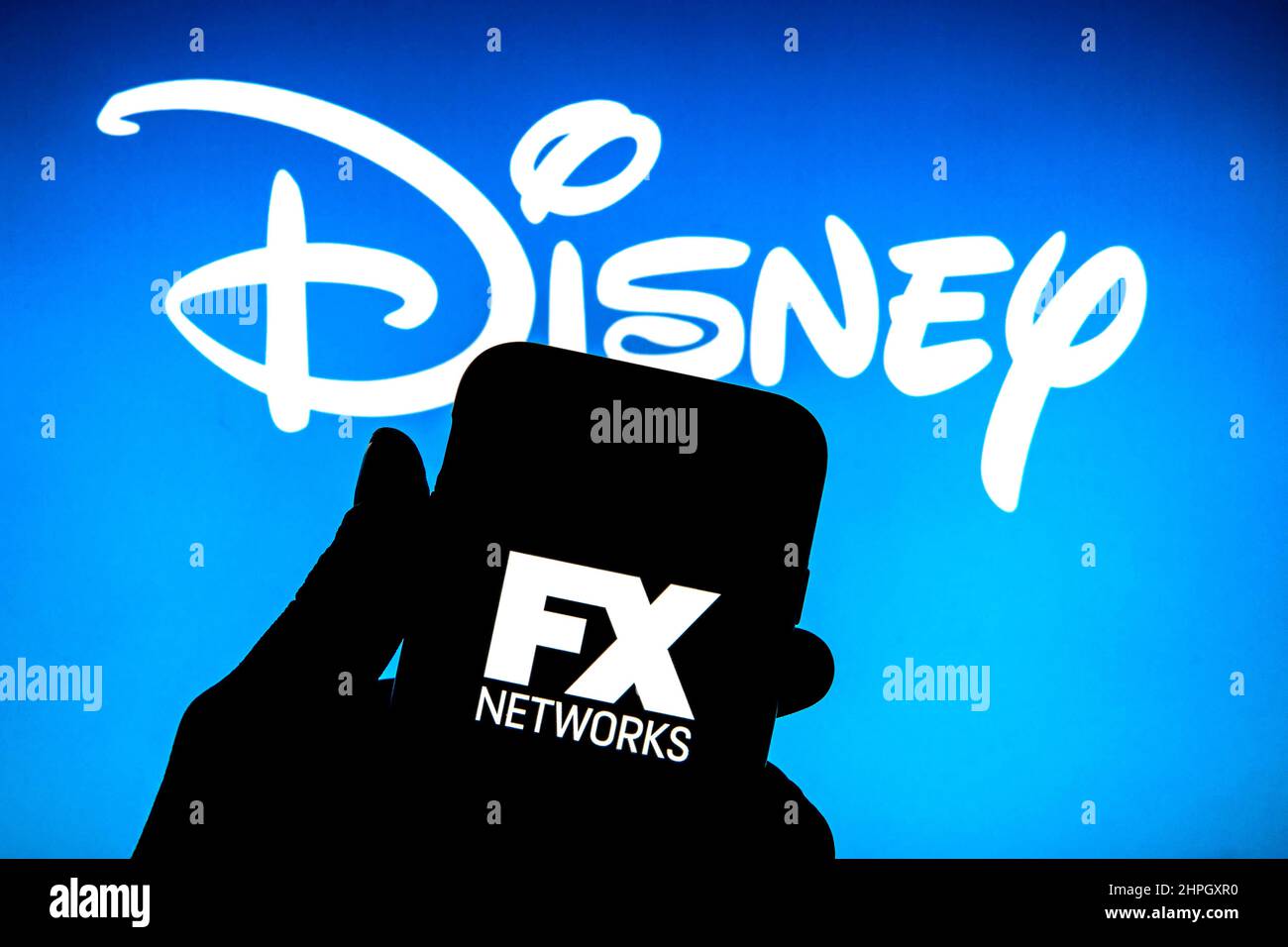 Spain. 17th Feb, 2022. In this photo illustration a FX Networks logo seen  displayed on a smartphone with a The Walt Disney Company logo in the  background. Credit: SOPA Images Limited/Alamy Live