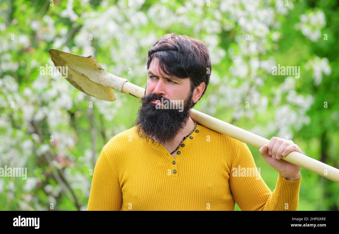 Bearded man with gardening shovel. Gardener working in garden. Farmer preparing to planting Plants. Stock Photo