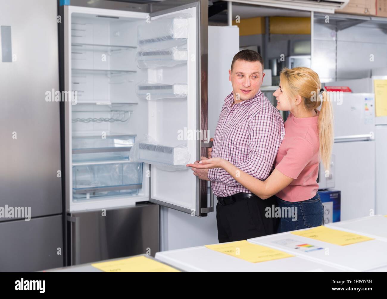 Picture Idea: Positive Family Couple Choosing New Refrigerator In Store Of Household