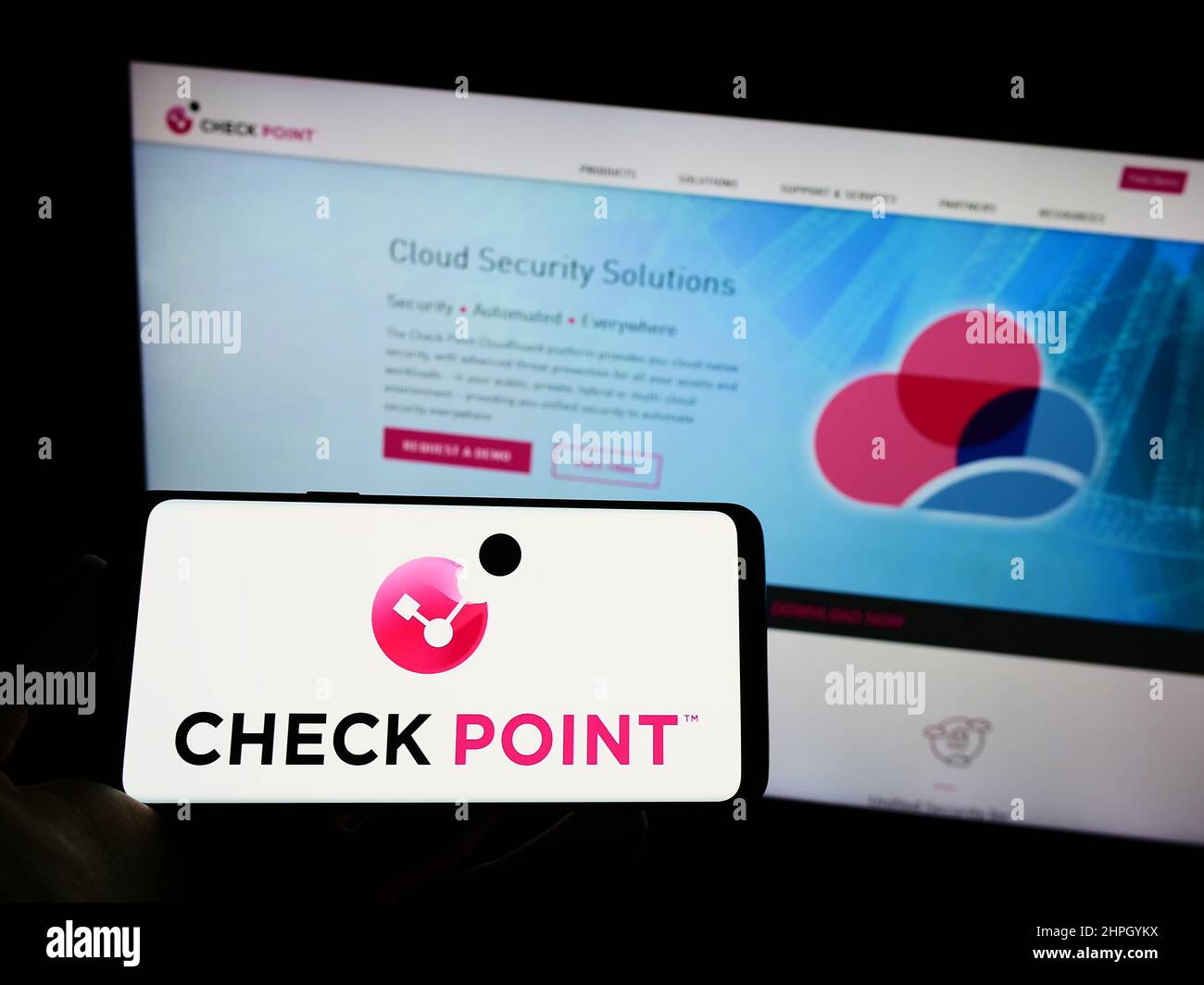 Person holding cellphone with logo of company Check Point Software Technologies Ltd. on screen in front of webpage. Focus on phone display. Stock Photo