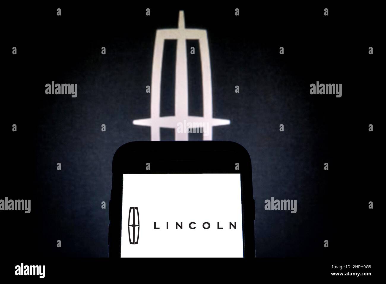 In this photo illustration a Lincoln Motor Company logo seen displayed on a smartphone with a Lincoln Motor Company logo in the background. (Photo by Thiago Prudencio / SOPA Images/Sipa USA) Stock Photo