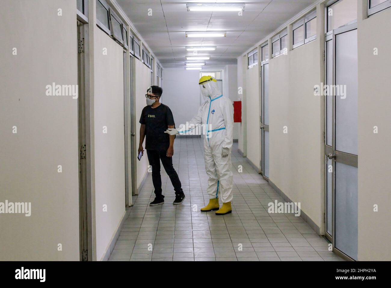 A health worker directs a patient to enter the isolation room during a ...