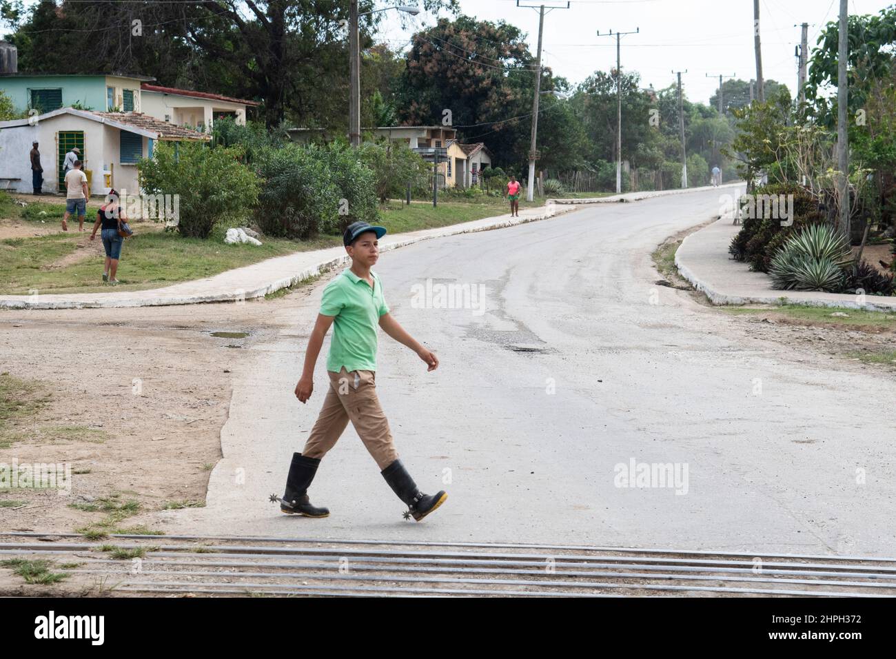 Young cowboy walks near a train track with spurs on his books in Trinidad, Cuba. Stock Photo
