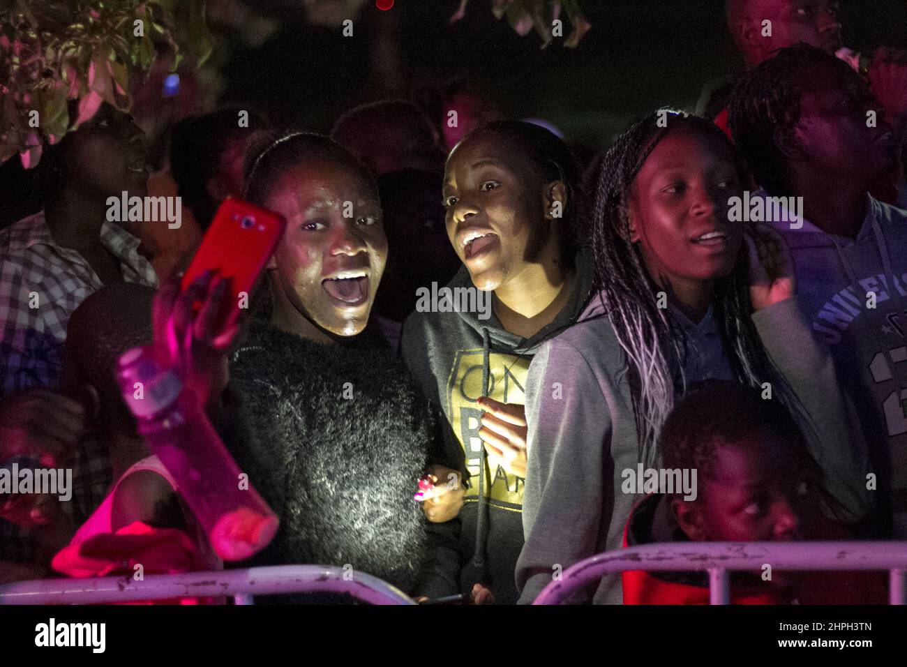 Young girls are seen singing along to the music at a free Christmas