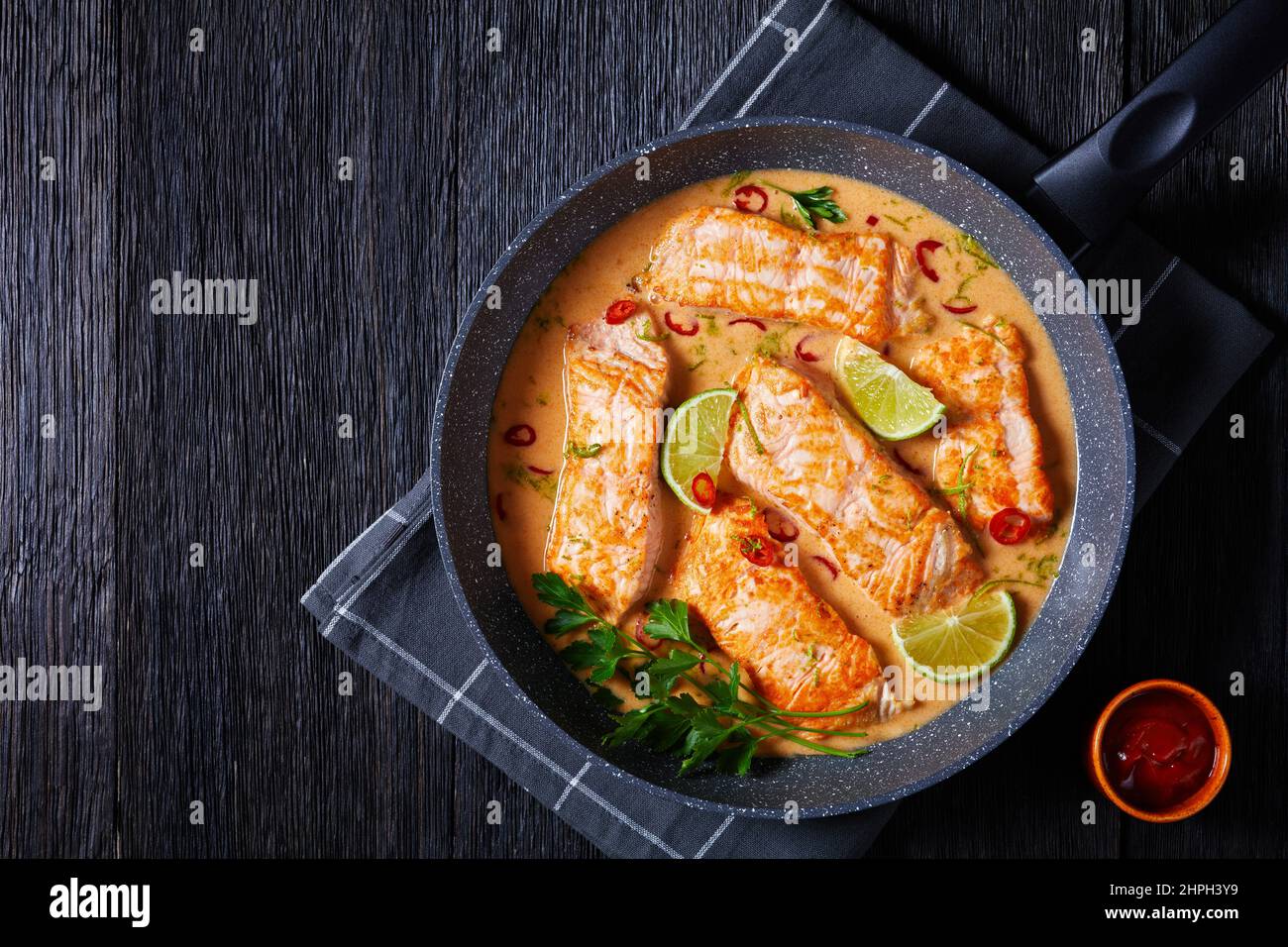 Poached Salmon in Coconut Lime Sauce, salmon fish curry in a pan on a