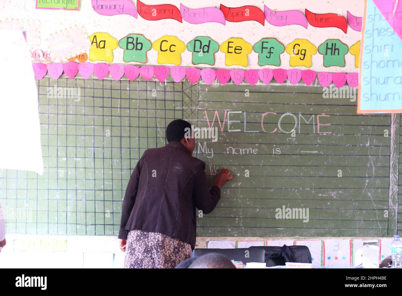 A teacher is seen writing on the board at Macheke Primary School, Zimbabwe. Stock Photo