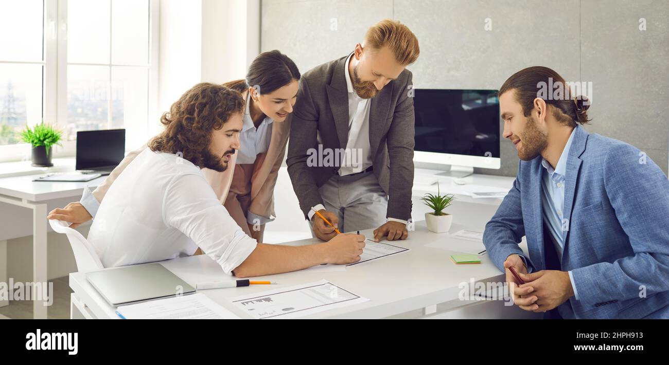 Employees reads, analyzes and edits paper documents while working in modern office center. Stock Photo