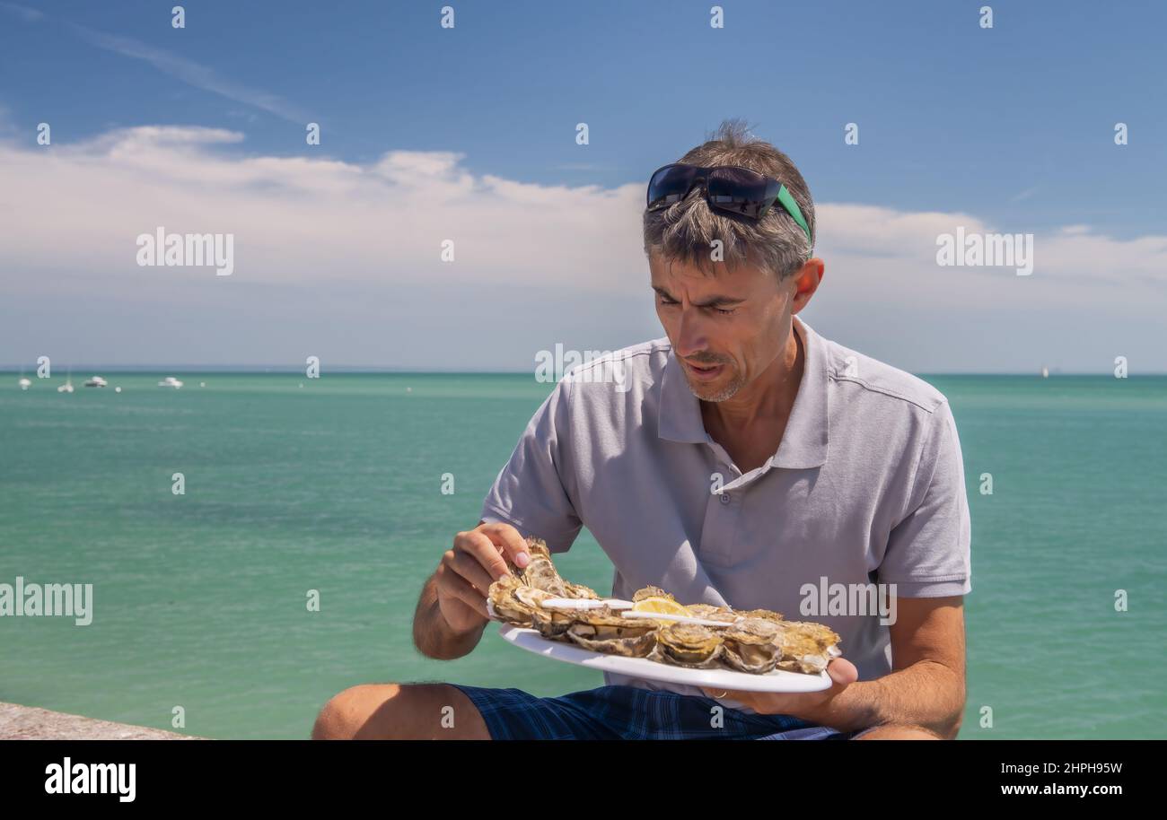 Man ready to eat a tray of fresh oysters outdoor Stock Photo