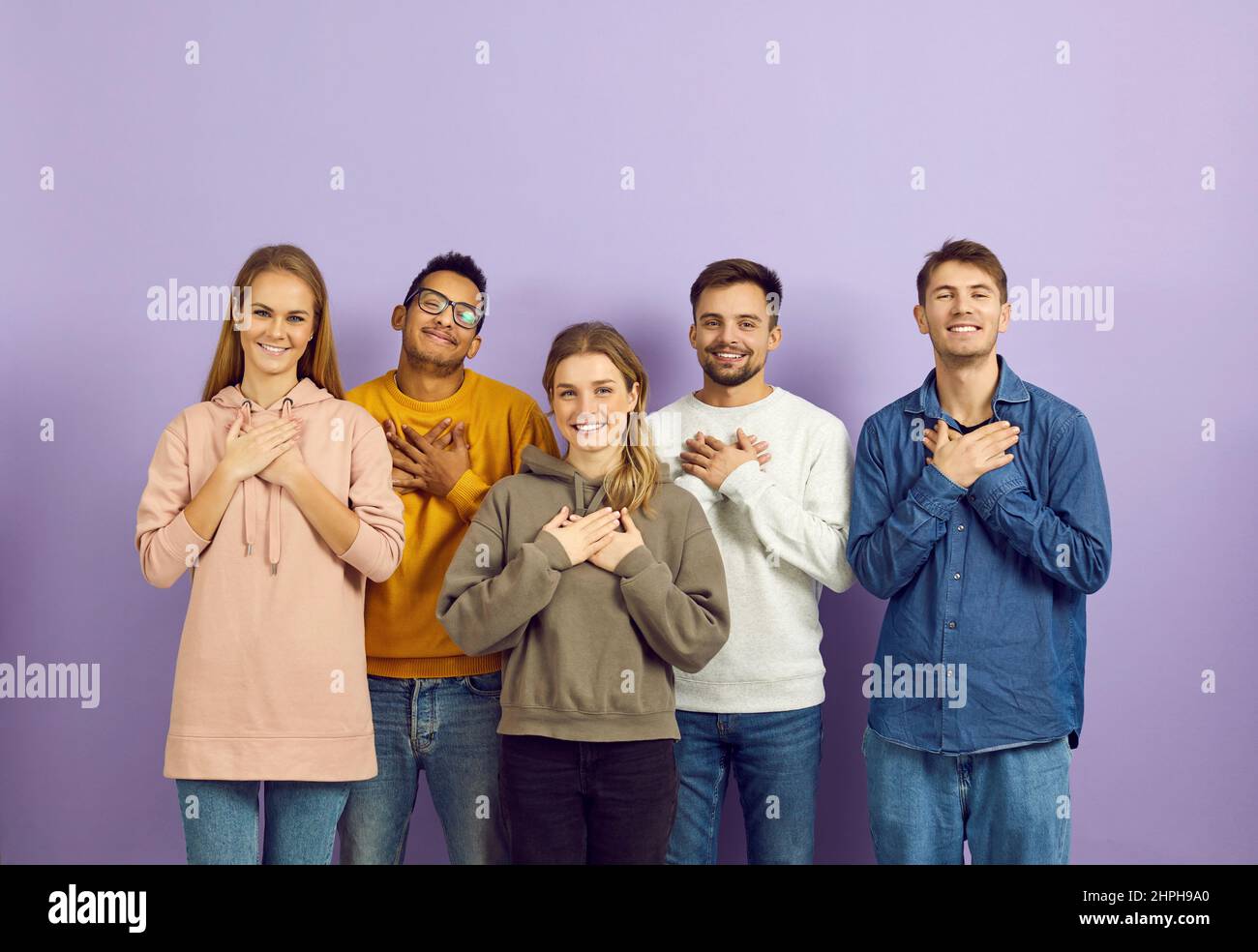 Happy people holding hands on their chests to express their gratitude and appreciation Stock Photo