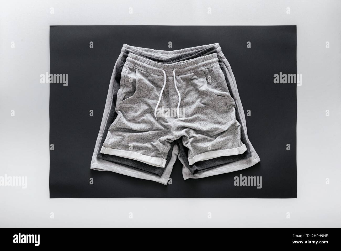 Crumpled gray black shorts pants for man sport. Set Various of Basic casual clothing sports gray male shorts On white black frame background Stock Photo